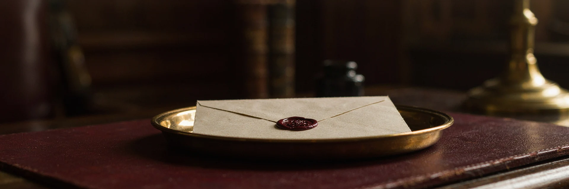 A wax-sealed envelope resting on a small gold tray.